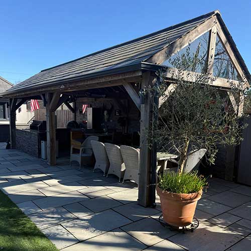 Completed oak-framed garden room with slate roof and patio