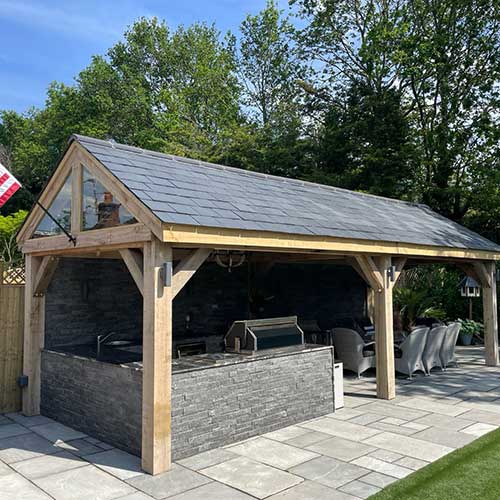 Oak-framed garden pavilion with slate roof and outdoor kitchen