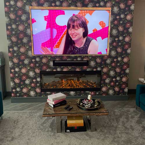 Media wall with wall-mounted TV and inset electric fire
