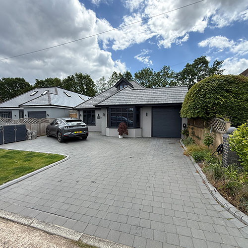 Front of remodelled bungalow with garage and block-paved driveway