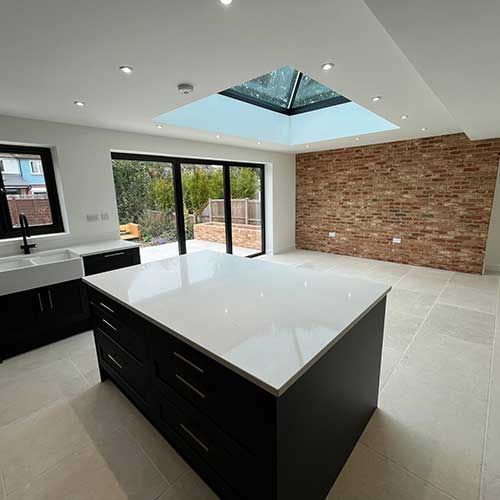 Open-plan kitchen extension with island, lantern roof and exposed brick