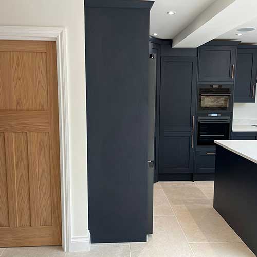 Dark navy shaker kitchen with island and oak internal door