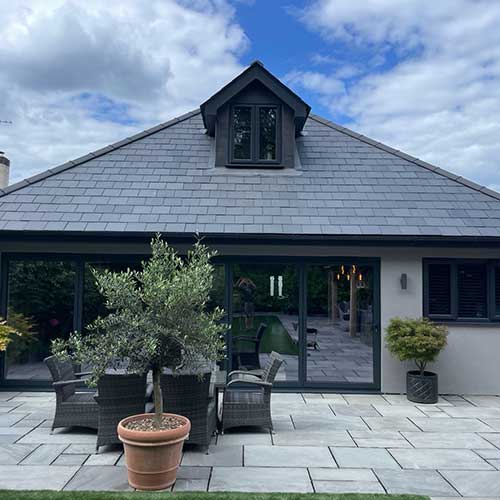 Rendered rear extension with sliding doors and slate dormer roof