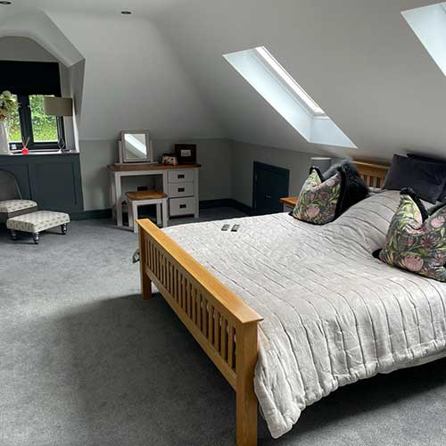Spacious loft conversion bedroom with sloped ceiling and rooflight
