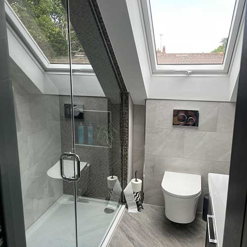 Loft en-suite shower room with tiled walk-in shower and rooflight