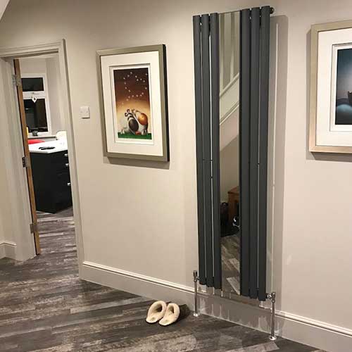 Hallway with anthracite vertical radiator and new plank flooring
