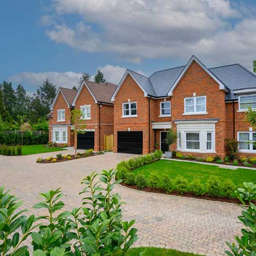 New-build red brick detached houses with integral garages and block paved drive