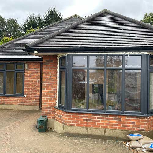 New bay and side windows fitted during bungalow renovation, brickwork drying