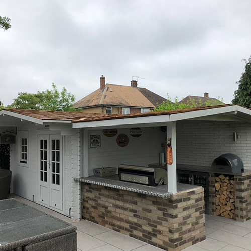 Garden room and outdoor kitchen with pitched cedar-shingle roof canopy