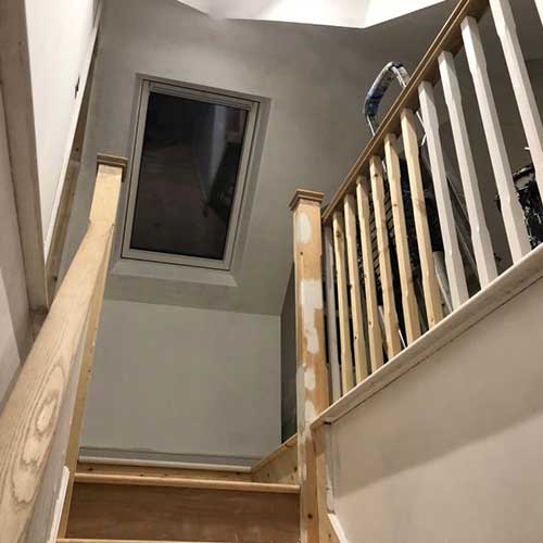 Loft conversion staircase with oak handrail and new roof window