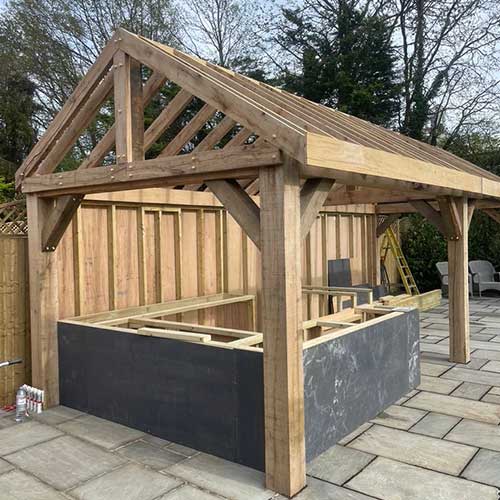 Oak-framed garden room under construction with timber trusses