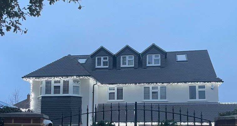 Rendered detached house with a dormer loft conversion at dusk