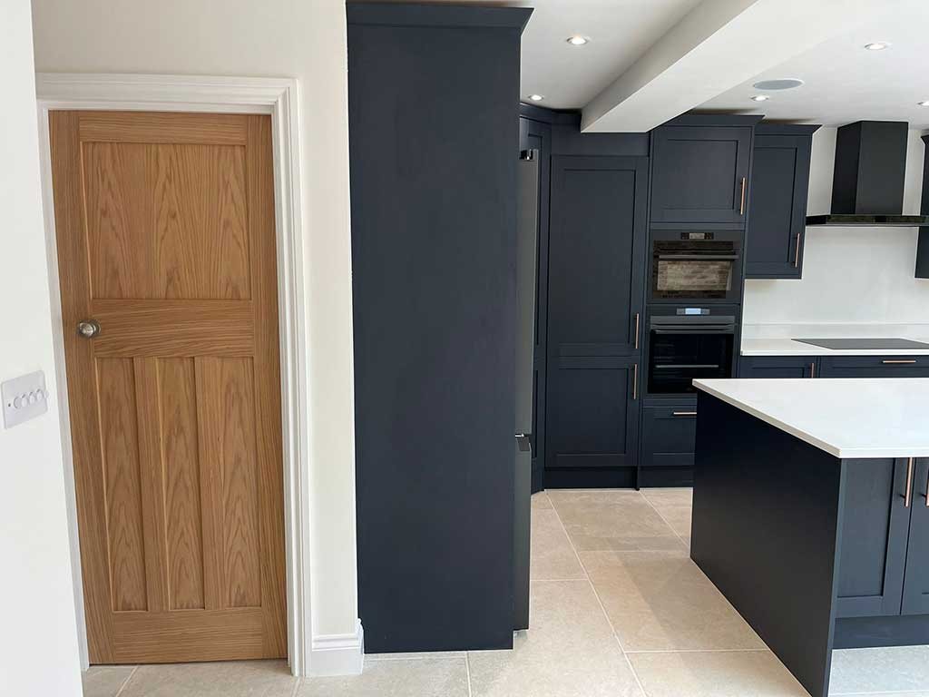 Dark navy shaker kitchen with an island and oak internal door