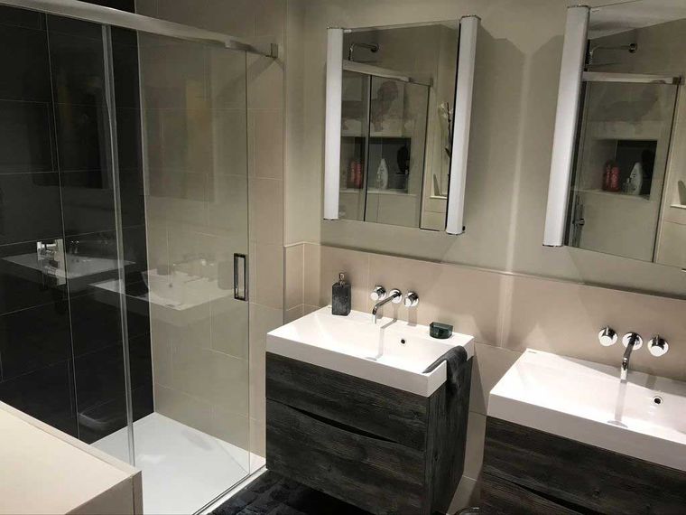 Modern bathroom with twin basins and a glazed shower enclosure