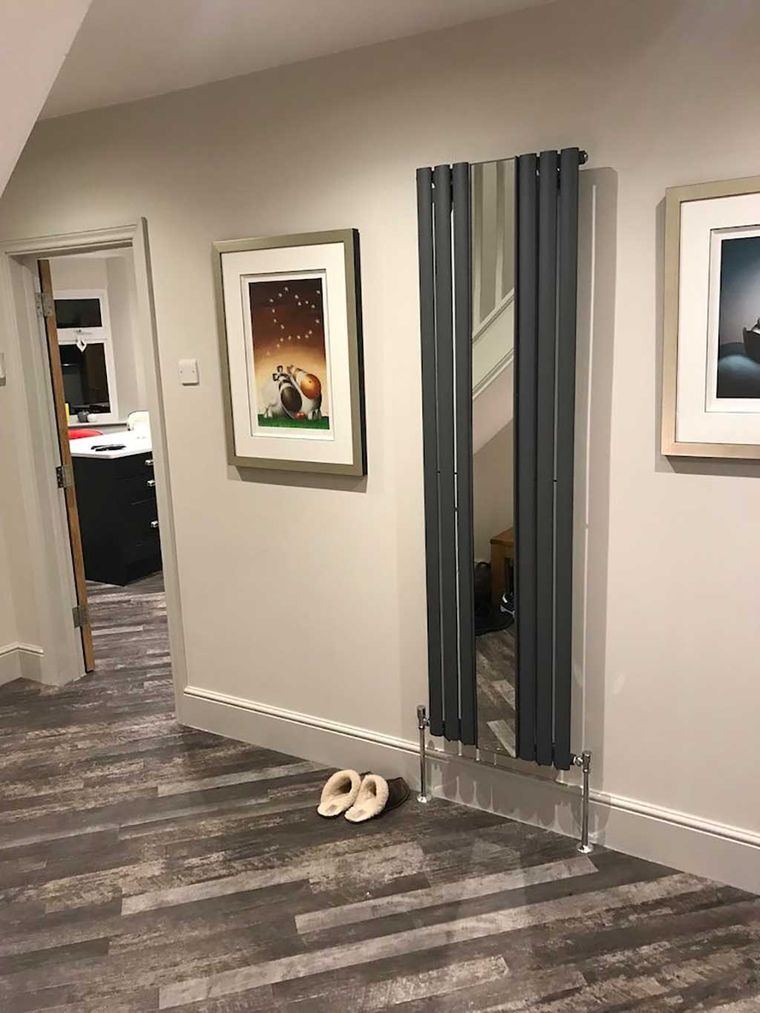 Hallway with an anthracite vertical radiator and new plank flooring