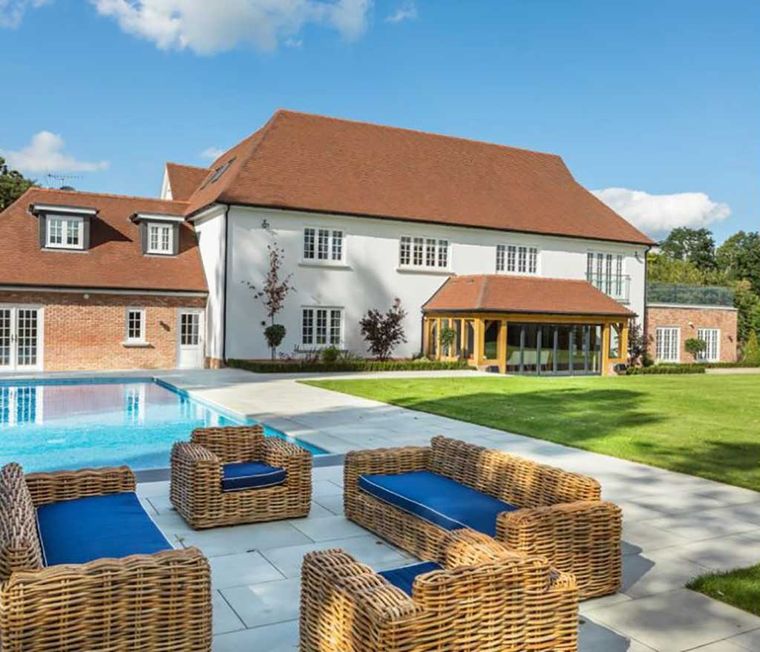 Large rendered and brick country house with an oak framed garden room and pool