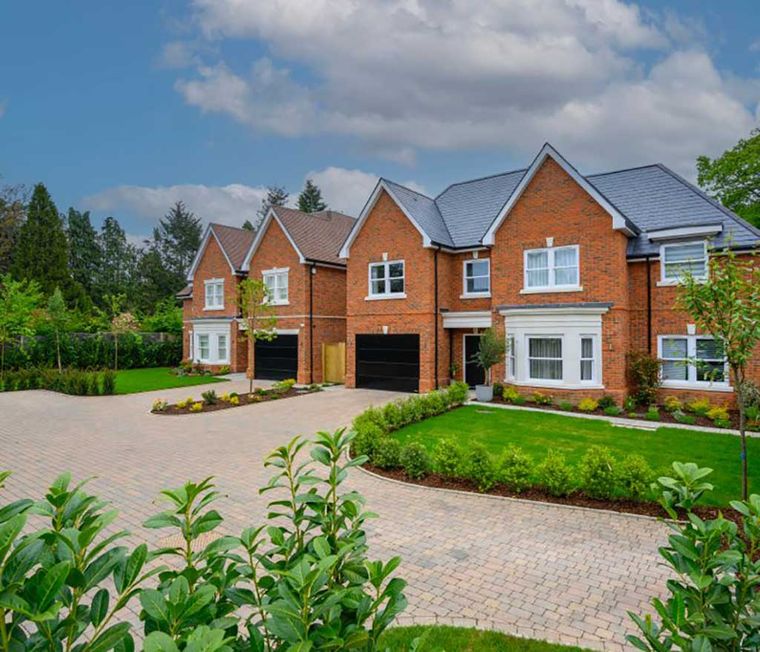 New build red brick detached houses with integral garages and a block paved drive