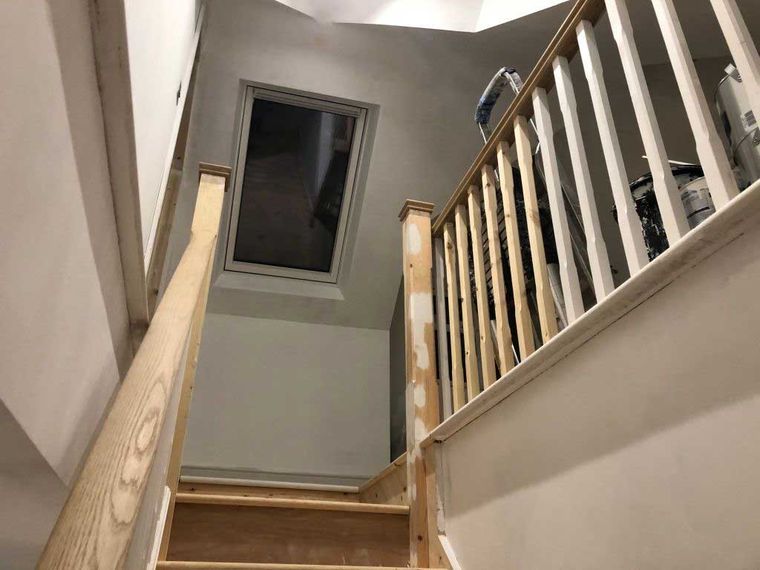 Loft conversion staircase with an oak handrail and new roof window