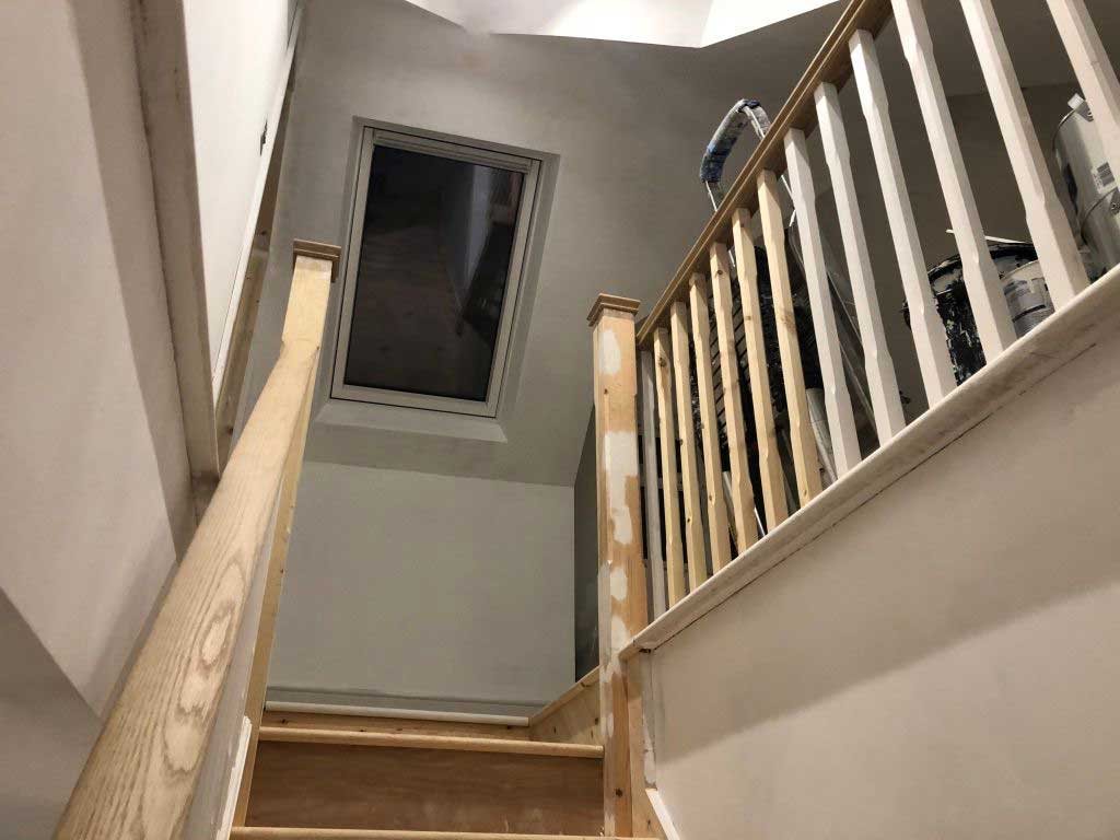 Loft conversion staircase with an oak handrail and new roof window
