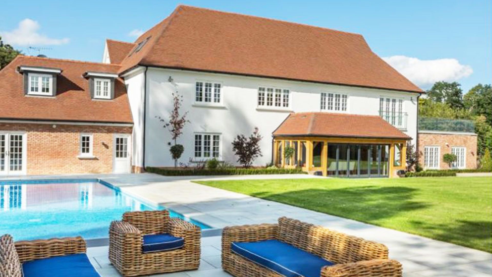 Large rendered and brick country house with an oak framed garden room and pool